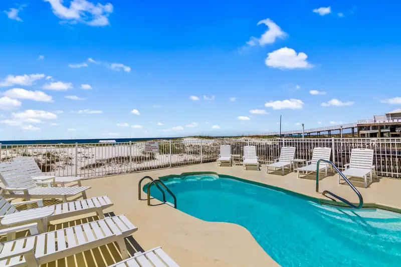 Dolphin View's beachside pool with loungers and the Gulf beyond